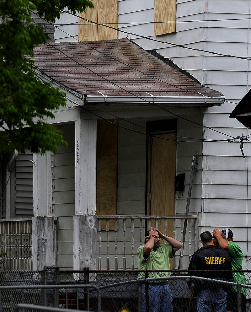 Sheriff’s department workers board up the home of kidnapping suspect Ariel Castro at 2207 Seymour Ave. in Cleveland after FBI personnel removed several items Friday.