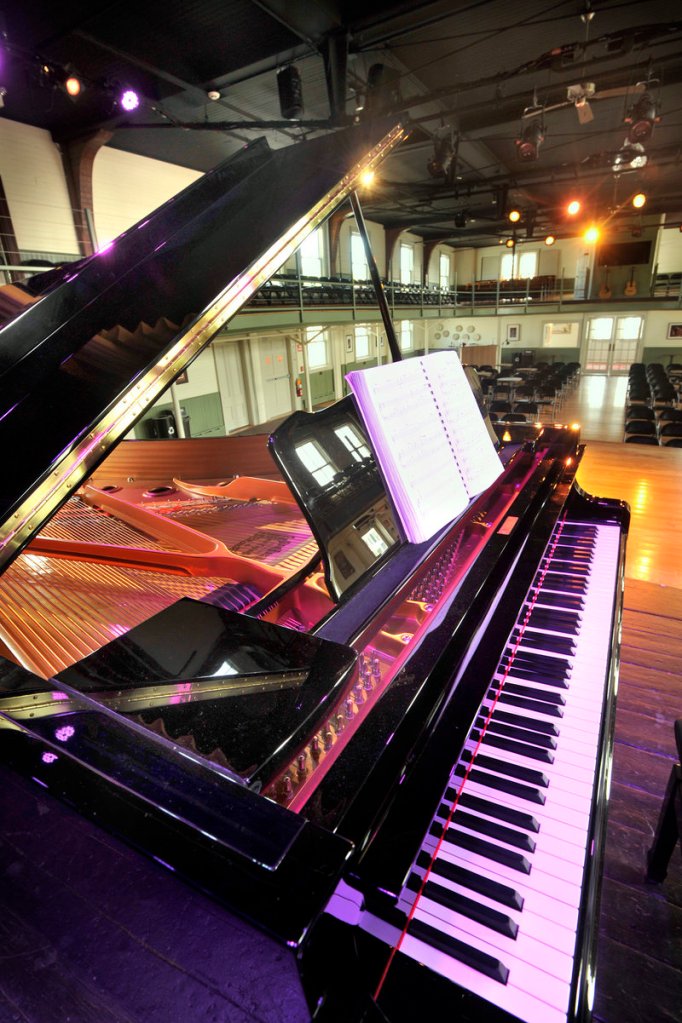 A grand piano graces the opera house stage.