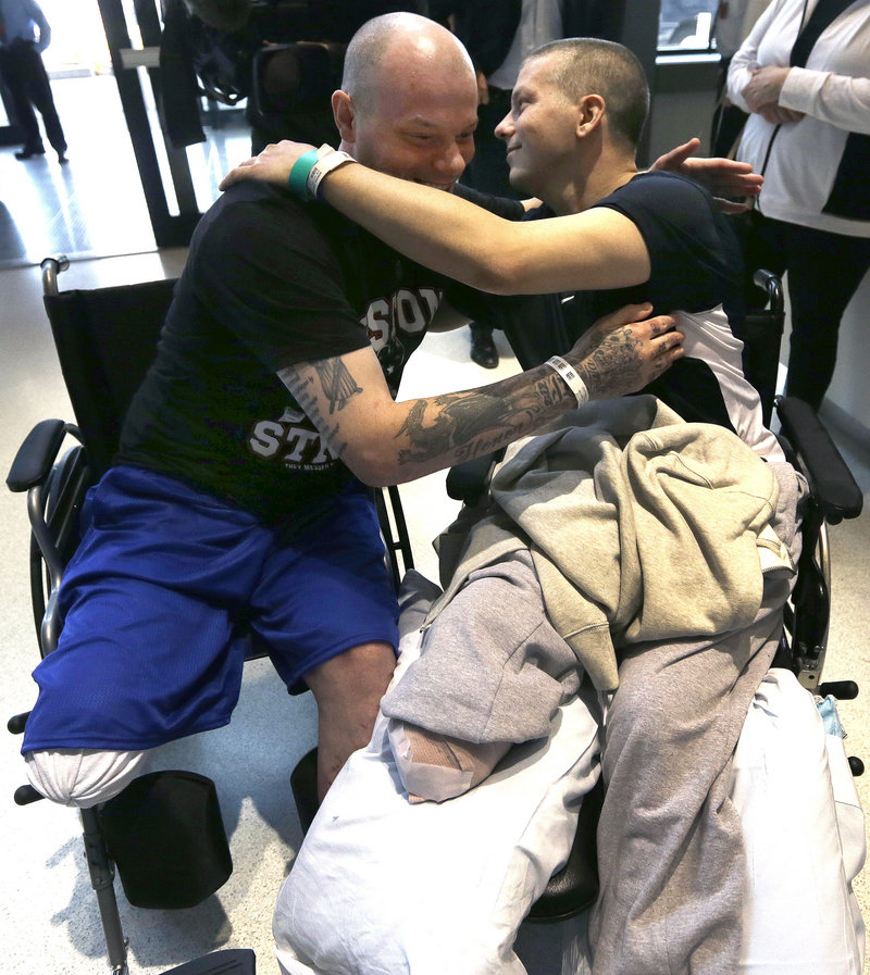 Paul Norden, left, and his brother J.P., right, both suffering limb-loss after the Boston Marathon bombing, embrace after a news conference at Spaulding Rehabilitation Hospital in Boston's Charlestown section Monday, May 13, 2013. (AP Photo/Elise Amendola)