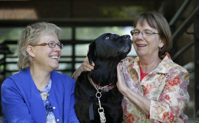 Courthouse dog Molly B sits with Ellen O’Neill-Stephens, right, a former prosecutor in Seattle who founded the Courthouse Dogs Foundation, and Celeste Walsen, left, the organization’s executive director.