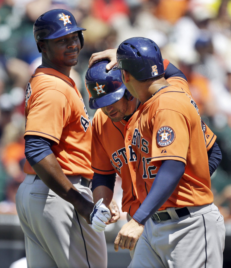 J.D. Martinez, center, is congratulated by Houston teammates Chris Carter, left, and Carlos Pena after his home run gave the Astros a 5-4 lead in a rare win over Detroit.
