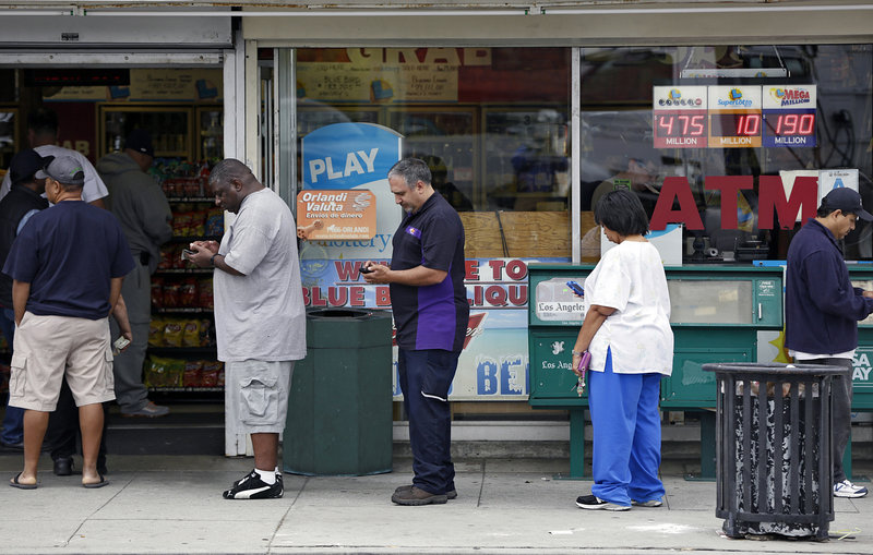 People line up to buy lottery tickets at the Bluebird Liquor store in Hawthorne, Calif., Thursday. The Powerball jackpot has soared to at least $550 million and by Saturday’s drawing likely will exceed the record set in December.