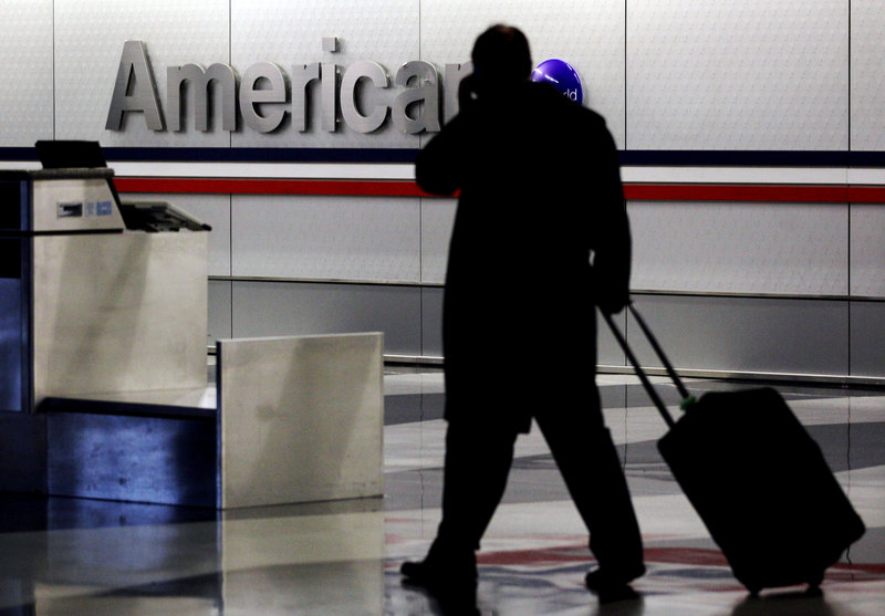 A passenger with a rolling suitcase walks through an American Airlines baggage claim area at O’Hare International Airport in Chicago in 2011.