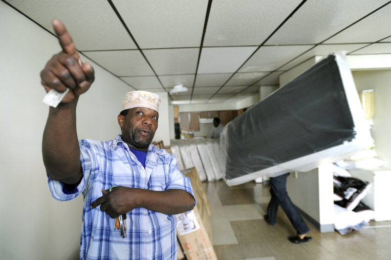 Displaced Lewiston fire victims get bedding, beds and furniture delivered to their new apartments Friday. Above, Ali Sheikh directs his family’s move into a new apartment at 49 Knox St. in Lewiston.