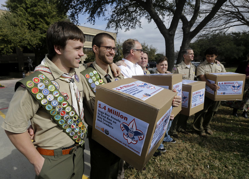 James Oliver, left, hugs his brother and fellow Eagle Scout Will Oliver, who is gay, as Will and other supporters carry four boxes filled with a petition to end the ban on gay scouts in February in Dallas.
