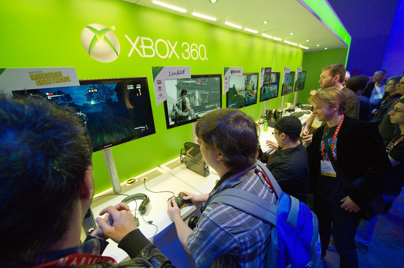 Attendees play with Microsoft’s Xbox 360 game console at the Consumer Electronics Show in Las Vegas. Microsoft faces threats from companies including Apple and Facebook.