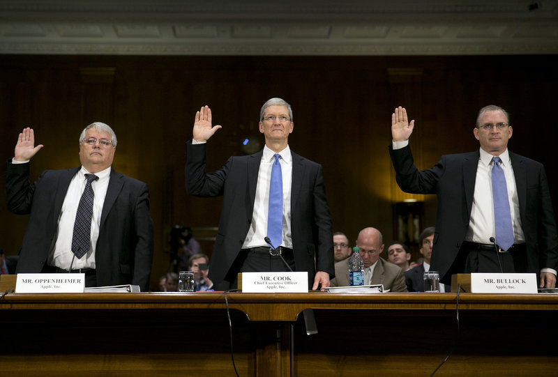 Apple executives are sworn in at Tuesday’s Senate hearing. From left are Peter Oppenheimer, senior vice president and chief financial officer; Tim Cook, chief executive officer; and Phillip Bullock, head of tax operations.