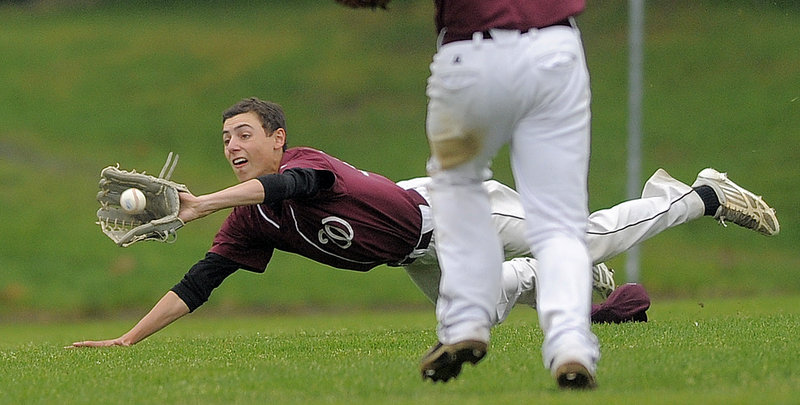 Andrew Whiting of Windham keeps his focus on the ball while heading to the ground and making a diving catch in left field.