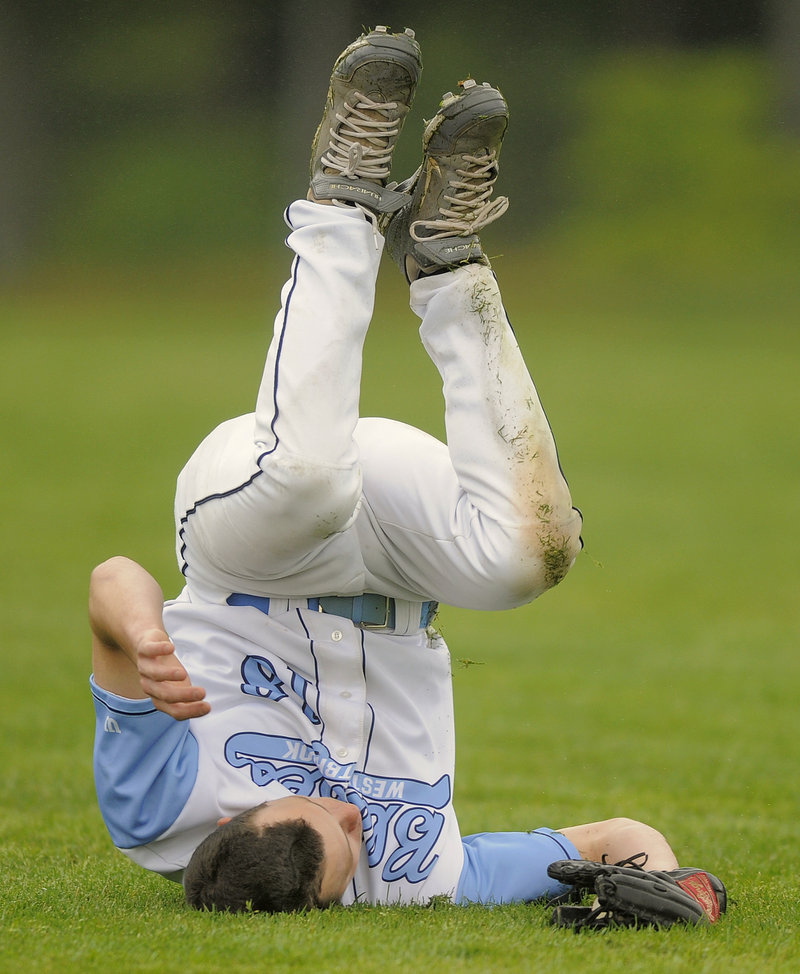 Ryan Gilligan of Westbrook ends up on his head Tuesday after making an acrobatic catch in left field during the SMAA game against Windham, which pulled away to a 7-2 victory.