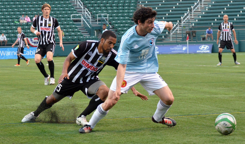 Clement Bompart of the Portland Phoenix, right, looks to make a play Tuesday night after slipping past Ross LeBauex of the Rochester Rhinos during their second-round game in the U.S. Open Cup. Rochester won, 1-0.