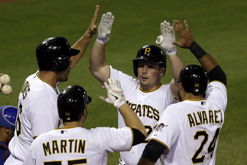 Pittsburgh’s Travis Snider is greeted at the plate by the three runners he delivered with a grand slam in the sixth inning of Pittsburgh’s 5-4 win over the visiting Cubs on Tuesday.