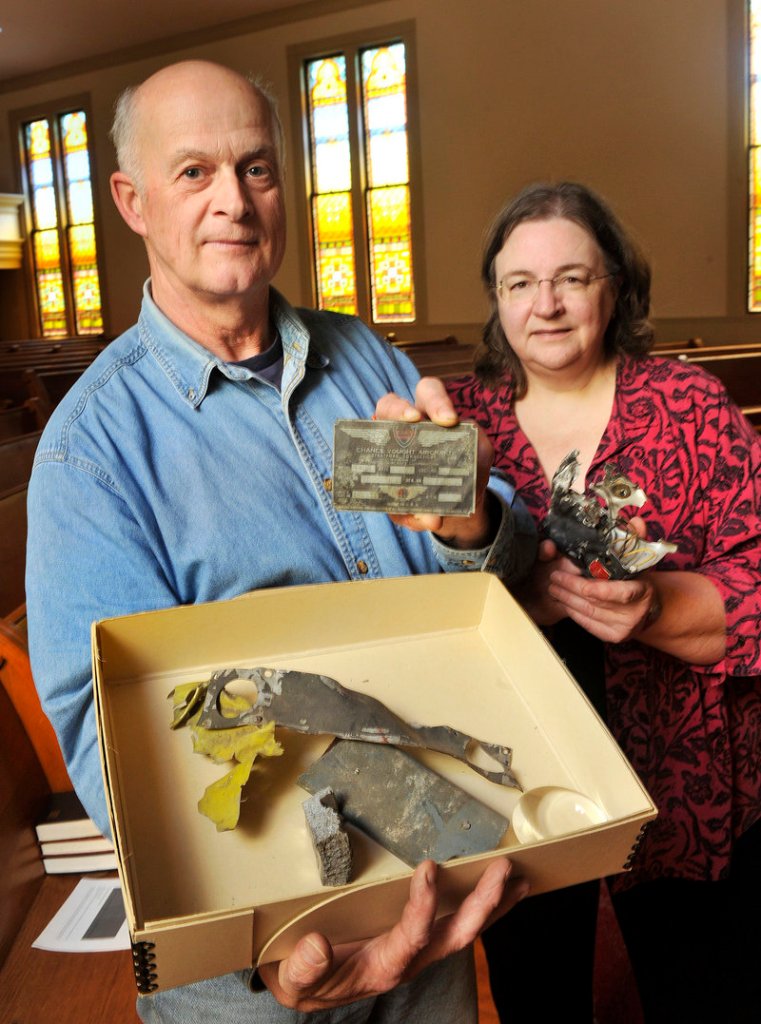 Phil Blake displays parts of a British fighter plane that were recovered after a midair crash over New Gloucester in 1943. He wants to add the pilots’ names to the town’s planned veterans monument. Town archivist Linda Gard, right, helped Blake research the incident.