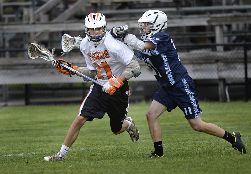 Chad Pelletier of Westbrook, right, applies the defense as Kyle Rhames of Biddeford looks for an opening on offense during their lacrosse game.