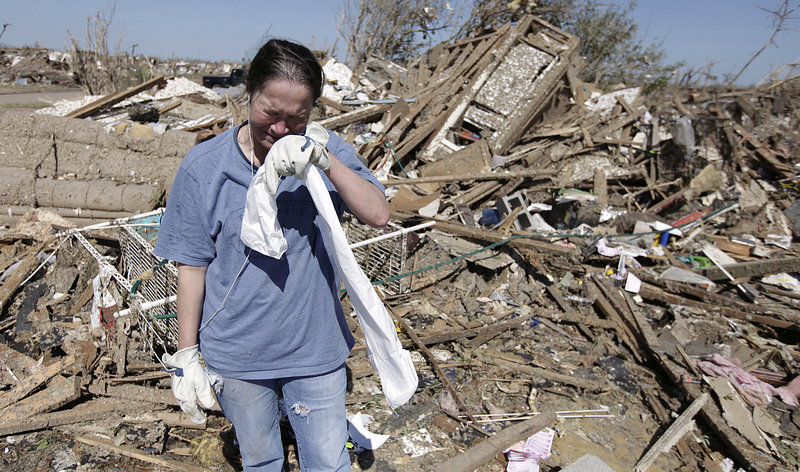 Kriket Krekemeyer weeps while digging through the remains of her tornado-ravaged home in Moore, Okla., Wednesday. The tornado may have created $2 billion or more in damage as it tore through as many as 13,000 homes, multiple schools and a hospital.