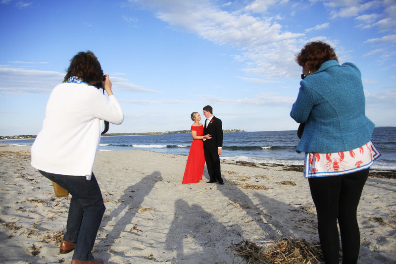 Mackenzie Leighton, a junior at Cape Elizabeth High School, and Connor Maguire, a senior, pose on the beach as they are photographed before the prom by their mothers, Gwyneth Maguire, left, and Susan Leighton, right, May 18. After the dance, the couples returned to a Pine Point cottage to eat the leftovers from the potluck, make s’mores and play guitar by a fire pit.