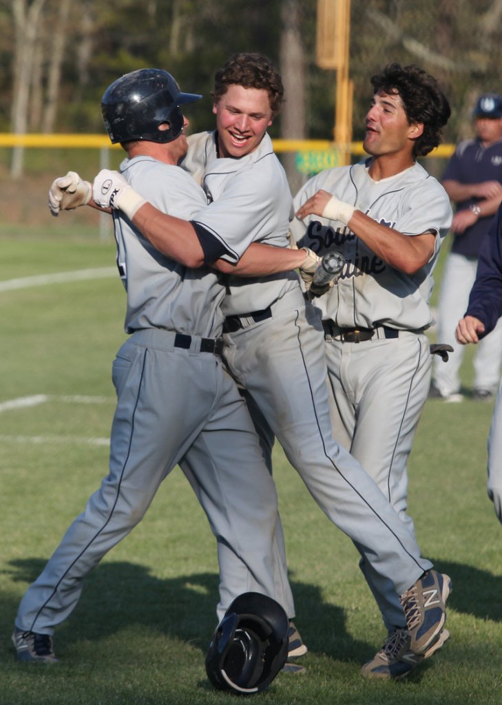 USM’s Sam Dexter, center, celebrates a tie-breaking home run Saturday against Endicott College that helped the Huskies win the NCAA Division III regional title.