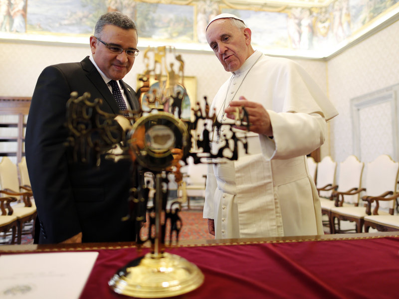 During a private audience at the Vatican on Thursday, Pope Francis speaks with El Salvador’s President Mauricio Funes as they stand in front of a reliquary containing a fragment of the vestment that archbishop Oscar Romero was wearing when he was assassinated.