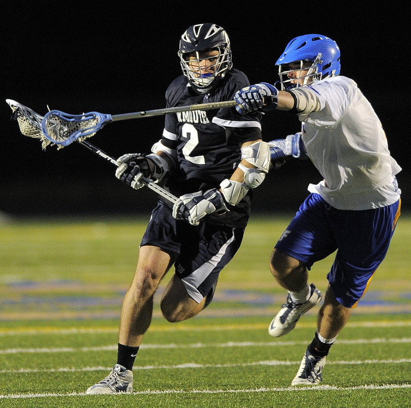 Quinn Hathcock of Yarmouth looks to work his way toward the goal Friday night while being defended by Brad Gilbert of Falmouth during their schoolboy lacrosse game. Yarmouth rallied late in regulation, then scored in overtime for a 15-14 victory.