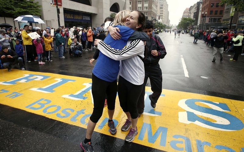 Rachel, left, and Pam Vingsness of Newton, Mass., embrace after crossing the finish line of the Boston Marathon. The two runners were unable to finish the marathon April 15 because of the bombings and were allowed to finish the last mile of the race with thousands of others in Boston on Saturday.