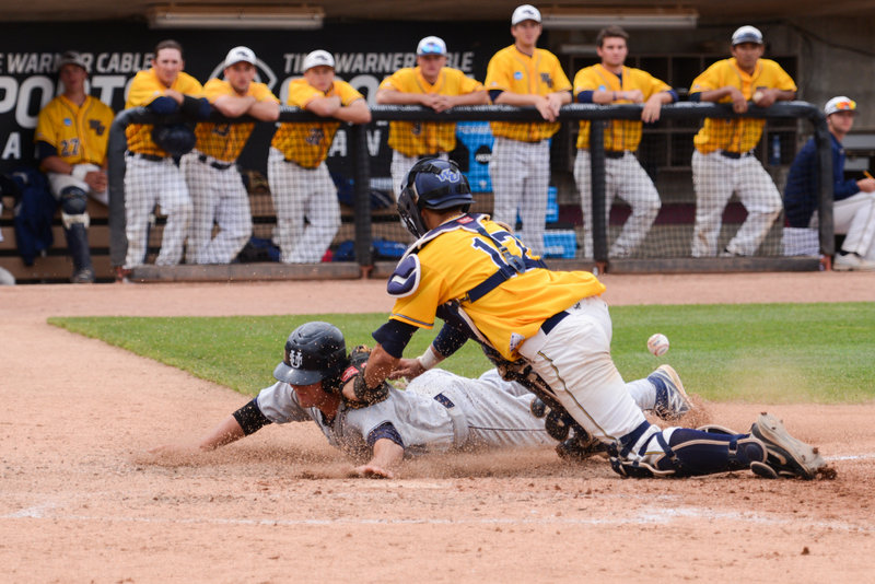 Forrest Chadwick dives across the plate to score a run for Southern Maine in the eighth inning as Webster catcher Ian Foege can’t handle the throw Sunday at Appleton, Wis.