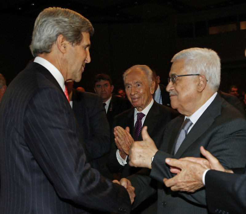 John Kerry shakes hands with Palestinian President Mahmoud Abbas, right, while Israeli President Shimon Peres, center, observes at the World Economic Forum on the Middle East and North Africa in Jordan on Sunday.