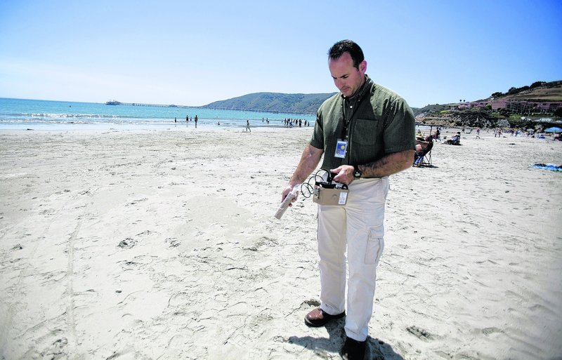 Scott Milner of the San Luis Obispo County Department of Environmental Health uses a radiation measuring device to check Avila Beach in California for any dangerous debris.