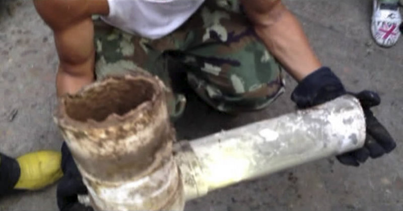 Above, a firefighter holds a section of a sewer pipe from an apartment building in China’s Zhejiang province where a newborn baby boy, below, was removed alive earlier this week. Pending further action, the infant was turned over to social services.