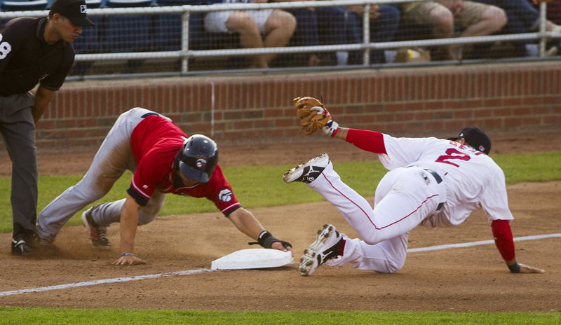 Portland third baseman Ryan Dent gets the throw late as New Hampshire baserunner Kevin Pillar advances safely during Thursday’s game in Portland, won by the Fisher Cats.