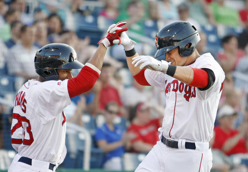 Tony Thomas, left, high-fives teammate Shannon Wilkerson, whose fifth-inning home run provided the Sea Dogs a cushion en route to a victory Friday night over the Altoona Curve at Hadlock Field.