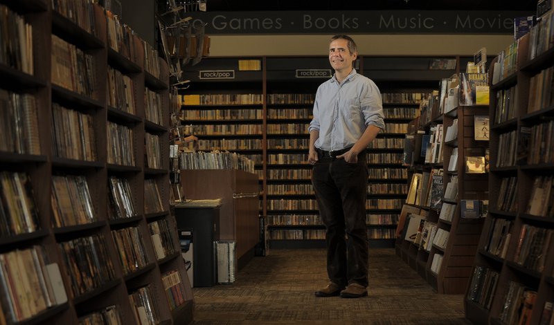 Bull Moose founder and sole owner Brett Wickard, shown in his South Portland store, says to compete with the big online book and music sellers, “It’s our job to listen to our customers and adapt and kind of roll with the punches.”