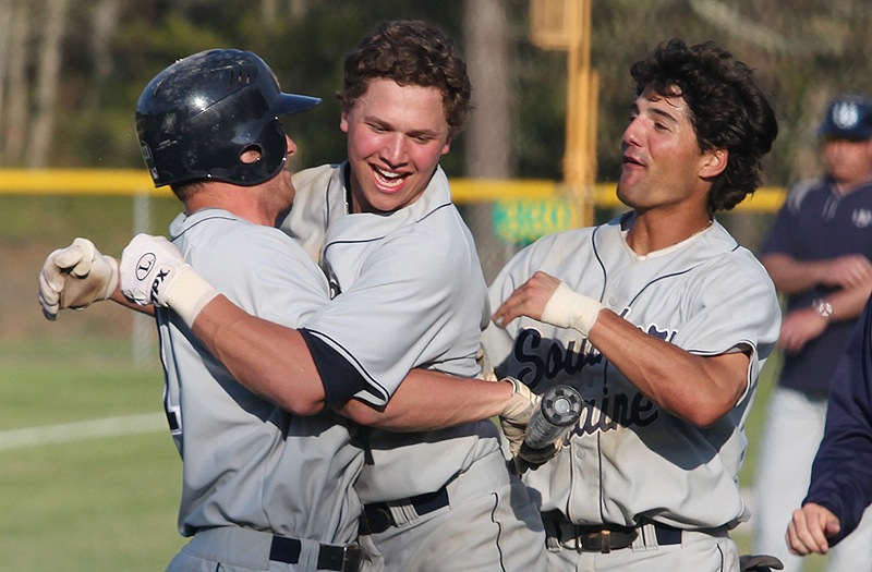 Sam Dexter, center, celebrates with teammates, including Anthony Pisani, right, after hitting a tiebreaking two-run homer in the ninth inning Saturday to propel Southern Maine to a 5-2 win over Endicott in the championship round of the NCAA Division III baseball regionals at Harwich, Mass.
