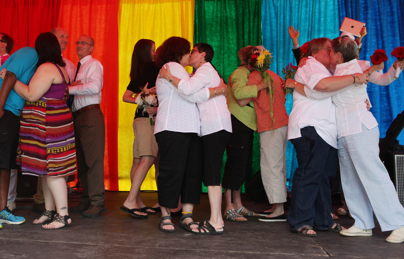 Newly married couples kiss following a mass wedding held Saturday in Deering Oaks Park in Portland as part of the Pride Parade and festival.