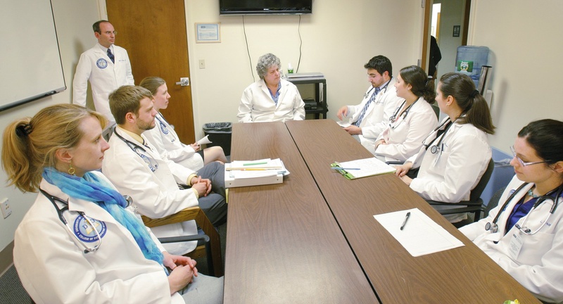 Elisabeth DelPrete, D.O., center, chair of the University of New England's department of family medicine, meets with medical students. Many of Maine's primary care doctors are UNE graduates.