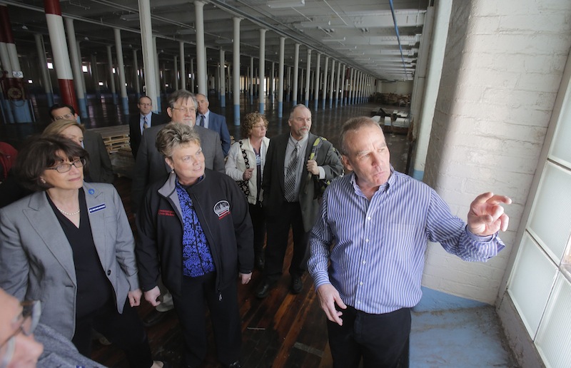 In this April 26, 2013 file photo, Doug Sanford, right, owner and developer of the North Dam Mill in Biddeford, gives a tour of the mill to state legislators of the Joint Select Committee on Maine's Workforce and Economic Future. The relatively high education level of Maine's work force is expected to spur growth in the manufacturing sector, according to a national "report card" issued Tuesday on each state's manufacturing-growth potential.
