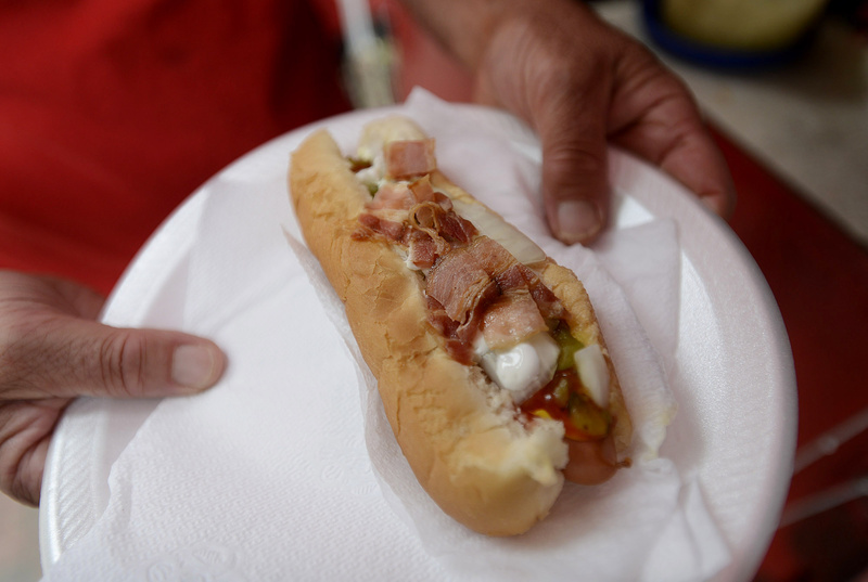 Mark Gatti of Mark's Hot Dogs serves an Old Porker in the Old Port on Monday.