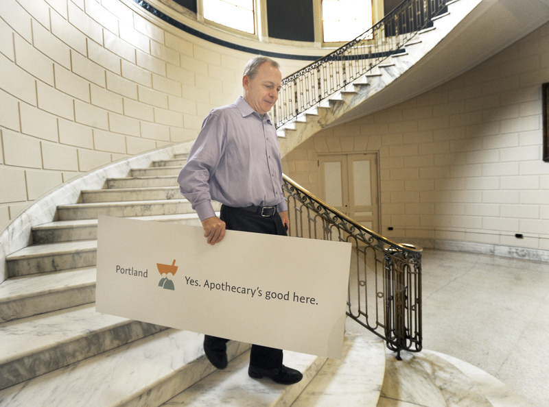 Apothecary by Design managing partner Mark McAuliffe leaves Portland City Hall after the city unveiled its new brand system to promote Portland. The sign shows how the slogan can be customized. Slogan