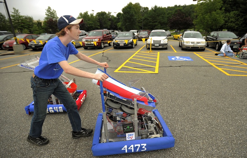 Colt Seigars, a homeschooler from Augusta, pushes his robot, "Zaphod," through a parking lot at Fairchild Semiconductor in South Portland Thursday.