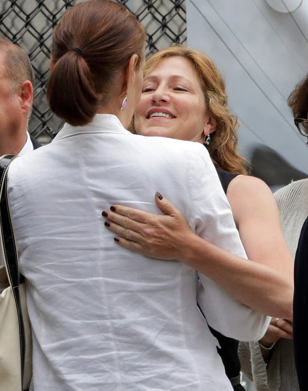 Actress Edie Falco embraces a woman as she arrives for the funeral service of James Gandolfini.