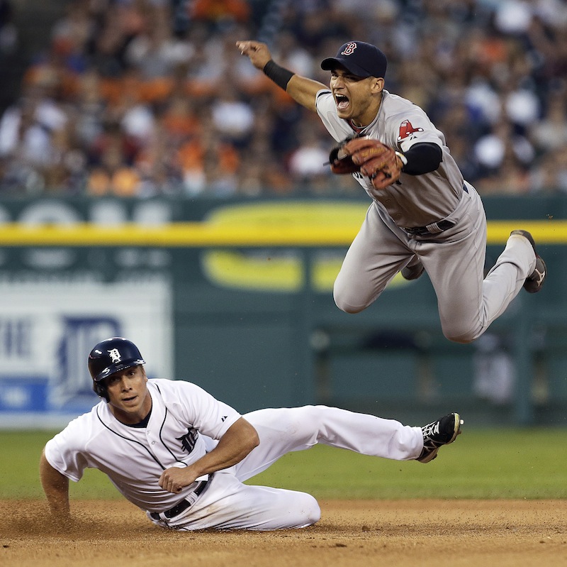 Boston Red Sox's Jose Iglesias jumps after Detroit Tigers' Andy Dirks slides to break up the throw to first base on a Brayan Pena fielder's choice in Detroit on Thursday. Pena was safe at first base.