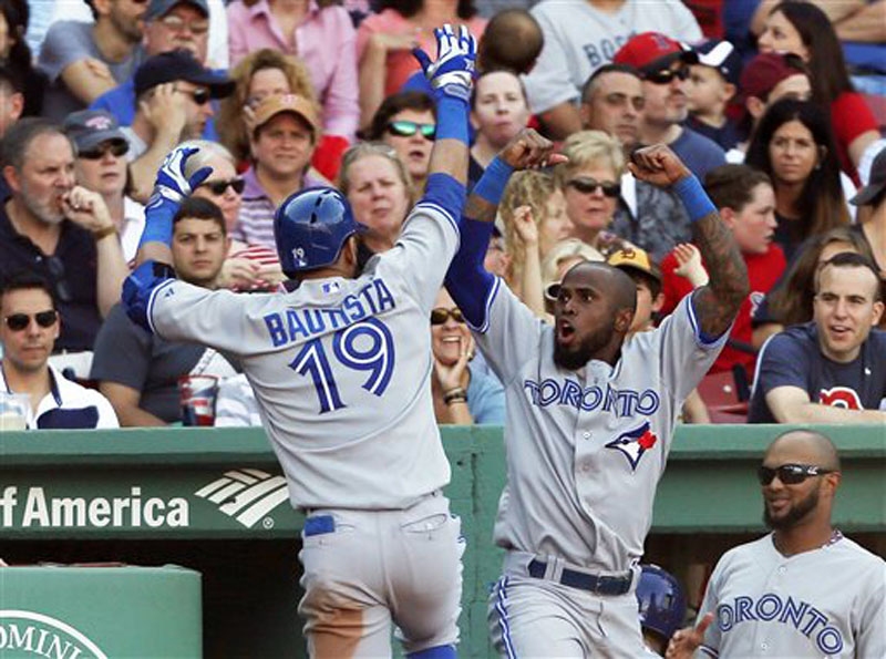 Toronto’s Jose Bautista, left, and Jose Reyes exult after Bautista’s two-run homer Saturday at Fenway Park. The Blue Jays beat the Red Sox, 6-2.