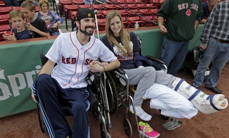 Boston Marathon bombing survivor Pete DiMartino, of Rochester, N.Y., and his girlfriend, Rebekah Gregory, hold hands prior to DiMartino throwing out the ceremonial first pitch before a Red Sox game at Fenway Park in Boston last month. DiMartino is among those applying for compensation from The One Fund.