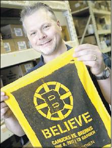 Boston Bruins fan Jim Joyce, right, who works at Maine Hardware in Portland, on Tuesday holds a towel from Game 4 of the 2011 Stanley Cup finals. Joyce attended the 2011 game with his brother.