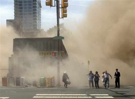 A dust cloud rises as people run from the scene of a building collapse on the edge of downtown Philadelphia on June 5, 2013, in this photo provided by Jordan McLaughlin.