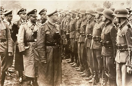 The June 3, 1944, photo provided by the U.S. Holocaust Memorial Museum shows Heinrich Himmler, center, head of the Gestapo and the Waffen-SS, and minister of the interior of Nazi Germany from 1943 to 1945, as he reviews troops of the Galician SS-Volunteer Infantry Division. Michael Karkoc a top commander whose Nazi SS-led unit is blamed for burning villages filled with women and children, lied to American immigration officials to get into the United States and has been living in Minnesota since shortly after World War II, according to evidence uncovered by The Associated Press.