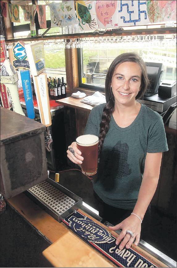 Katie Margo, a bartender at Flatbread Company in Portland, serves up a Baxter Amber Road