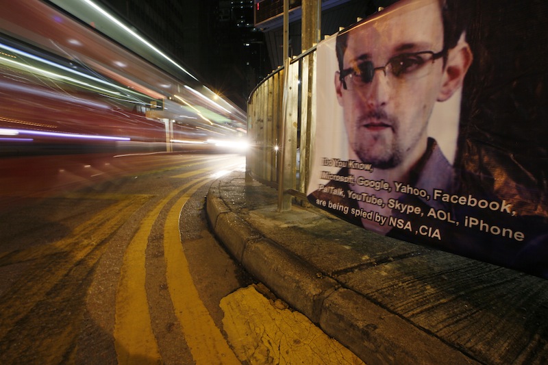 A bus drives past a banner supporting Edward Snowden, a former CIA employee who leaked top-secret documents about sweeping U.S. surveillance programs, at Central, Hong Kong's business district, Tuesday, June 18, 2013. Snowden, the National Security Agency leaker, is defending his disclosure of top-secret U.S. spying programs in an online chat Monday with Britain's Guardian newspaper and attacked U.S. officials for calling him a traitor. (AP Photo/Kin Cheung)