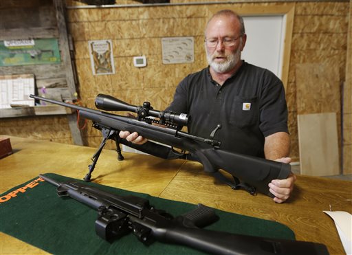 Jim Sowash handles a rifle at his gun shop near Stover, Mo., on Thursday. Sowash signed a letter to Missouri Gov. Jay Nixon urging him to sign a bill nullifying federal gun laws.