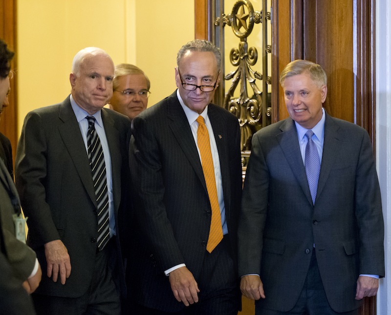 Members of the bipartisan "Gang of Eight" who crafted the immigration reform bill, Sen. Chuck Schumer, D-N.Y., center, flanked by Sen. John McCain, R-Ariz., left, and Sen. Lindsey Graham, R-S.C., leave the floor after final passage in the Senate on Thursday. Sen. Robert Menendez, D-N.J., follows at rear.