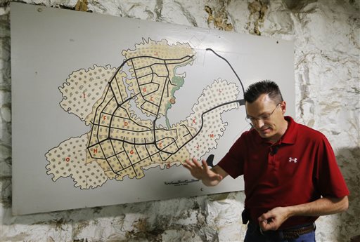 Coby Cullins stands next to a map of the Vivos Shelter and Resort during a tour of the facility in Atchison, Kan., on Tuesday.