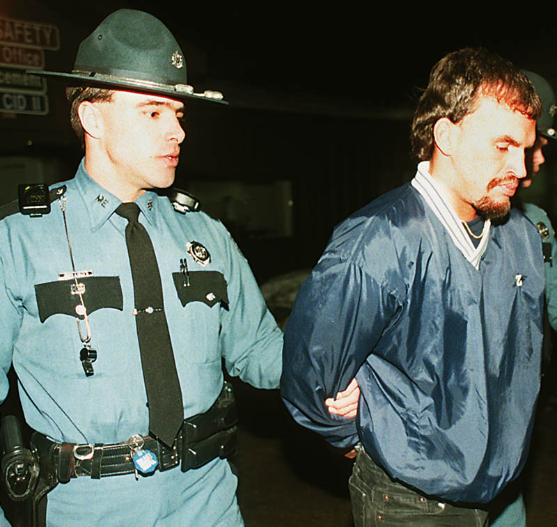 Trooper Joseph Mills II leads Guy E. Hunnewell III from the State Police Criminal Investigation Division in Augusta where he was detained after being arrested at the Comfort Inn in 1998. Hunnewell later pleaded guilty to murder.